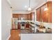 Well-lit kitchen featuring stainless steel appliances, wood cabinets, granite countertops, and stylish backsplash at 6404 Mayra Shores Ln, Apollo Beach, FL 33572