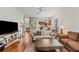 Spacious living room with hardwood floors, a comfortable sofa, and a view into the dining area and kitchen at 6404 Mayra Shores Ln, Apollo Beach, FL 33572