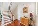 Elegant staircase with wood steps and white risers, complemented by hardwood flooring and a decorative painting at 6404 Mayra Shores Ln, Apollo Beach, FL 33572
