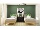 Inviting bedroom with twin beds, dark wood furnishings, and stylish green accent wall at 6483 Propel Run, New Port Richey, FL 34655