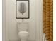 A contemporary bathroom features a toilet, framed leaf art, and a striped shower curtain at 8506 Sea Ray Run, Parrish, FL 34219