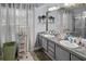 Bathroom with double sinks, granite counters, decorative mirrors, and soft natural light at 8712 Ashbury Dr, Hudson, FL 34667