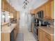 Galley style kitchen featuring wood cabinets and stainless steel appliances at 8712 Ashbury Dr, Hudson, FL 34667