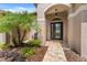 Elegant front entrance featuring a black door with glass accents and meticulously landscaped surroundings at 9412 Azalea Ridge Cir, Tampa, FL 33647