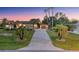 Expansive property showcasing the home's layout, including the long driveway and manicured lawn, set against a picturesque sky at 10117 Breezy Pines Ct, Weeki Wachee, FL 34613