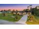 Wide angle view showcasing the home, lengthy drive, and lush landscaping, complete with palm trees and verdant lawn at 10117 Breezy Pines Ct, Weeki Wachee, FL 34613