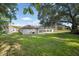 Expansive backyard with lush green lawn and screened-in porch, perfect for outdoor activities and entertaining at 10117 Breezy Pines Ct, Weeki Wachee, FL 34613
