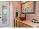 Bathroom featuring wood vanity, vessel sink, decorative mirror and decor and access to a courtyard at 10117 Breezy Pines Ct, Weeki Wachee, FL 34613