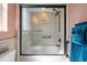 Bathroom featuring a bathtub and shower with frosted glass doors, complemented by blue accent towels at 10117 Breezy Pines Ct, Weeki Wachee, FL 34613