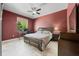 Well-lit bedroom features tile flooring, a ceiling fan, a window with blinds, and a desk at 10117 Breezy Pines Ct, Weeki Wachee, FL 34613
