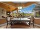Dining area surrounded by windows with a view of the pool, seating 6 at a wooden table with leather bench at 10117 Breezy Pines Ct, Weeki Wachee, FL 34613