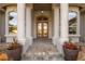 Detailed view of the front entrance with stone columns, double doors, and vibrant flower pots accenting the stone walkway at 10117 Breezy Pines Ct, Weeki Wachee, FL 34613