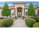 Stately entrance with stone walkway, manicured bushes, columns, and double doors, creating a welcoming and impressive facade at 10117 Breezy Pines Ct, Weeki Wachee, FL 34613