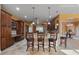 Spacious kitchen with dark wood cabinetry, stainless appliances, tile floors and center island with seating at 10117 Breezy Pines Ct, Weeki Wachee, FL 34613