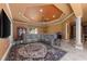 Open living room featuring a leather couch, rug, coffered ceilings, and natural light at 10117 Breezy Pines Ct, Weeki Wachee, FL 34613