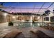 Enclosed pool with spa, waterfall feature, plants, brick pavers and modern furniture at 10117 Breezy Pines Ct, Weeki Wachee, FL 34613
