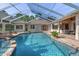 Breathtaking view of the private pool area with a unique rock waterfall and ample lounge seating at 10117 Breezy Pines Ct, Weeki Wachee, FL 34613