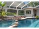Enclosed pool area with rock waterfall feature, in-pool seating and outdoor bar at 10117 Breezy Pines Ct, Weeki Wachee, FL 34613