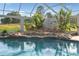 Pool featuring a rock waterfall and spa with backyard views from enclosure at 10117 Breezy Pines Ct, Weeki Wachee, FL 34613