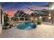 Enclosed pool with spa, waterfall feature, plants, and brick pavers at 10117 Breezy Pines Ct, Weeki Wachee, FL 34613