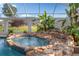 Pool featuring a rock waterfall and spa with access to the backyard at 10117 Breezy Pines Ct, Weeki Wachee, FL 34613