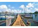 A marina with docks with slips for boats surrounded by yachts and a view of the water at 10355 Paradise Blvd # 413, Treasure Island, FL 33706