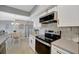 Modern kitchen featuring white cabinets, stainless steel appliances and adjacent dining area at 10355 Paradise Blvd # 413, Treasure Island, FL 33706