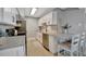 Contemporary kitchen featuring white cabinets, stainless steel appliances, and a cozy breakfast bar at 10355 Paradise Blvd # 413, Treasure Island, FL 33706