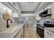 Remodeled kitchen showcasing white cabinets, stainless appliances and open layout with dining area at 10355 Paradise Blvd # 413, Treasure Island, FL 33706