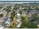 Picturesque aerial view of a residential area featuring mature trees, sparkling swimming pools, and charming homes near a tranquil lake at 11029 90Th Ave, Seminole, FL 33772
