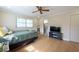 Inviting bedroom with wood-look floors, ceiling fan, natural light, and an adjacent bathroom at 11029 90Th Ave, Seminole, FL 33772
