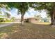 Quaint home with well-kept lawn, mature trees, and a driveway leading to an attached garage at 11029 90Th Ave, Seminole, FL 33772