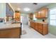 Bright kitchen with wooden cabinets, light-colored countertops, tile flooring, and an open view into the adjacent living spaces at 11029 90Th Ave, Seminole, FL 33772