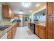 Traditional kitchen with wooden cabinets, stainless steel appliances, tile floors, and an open layout to the living area at 11029 90Th Ave, Seminole, FL 33772