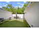 Well-maintained backyard featuring green artificial turf and patio dining area with table and chairs at 11227 Moultrie Pl, Tampa, FL 33625