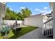 Private backyard featuring a dining set, turf lawn, white vinyl fence, and a detached garage at 11227 Moultrie Pl, Tampa, FL 33625