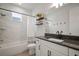 Modern bathroom with white vanity, granite countertop, and stylish shower-tub combination with white tile surround at 11227 Moultrie Pl, Tampa, FL 33625