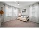 Bright bedroom with large windows, neutral walls, and ceiling fan with metal frame daybed and guitar accent at 11227 Moultrie Pl, Tampa, FL 33625