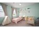 Bright bedroom featuring a crib and play tent near large windows with decorative banner and ceiling fan at 11227 Moultrie Pl, Tampa, FL 33625