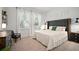 Well-lit bedroom with neutral tones, plush carpets, modern furniture, and large windows at 11227 Moultrie Pl, Tampa, FL 33625
