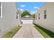 Long driveway leading to a detached garage between two modern white homes at 11227 Moultrie Pl, Tampa, FL 33625