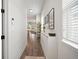 Long entry hallway with hardwood floors, storage cabinets, modern wall art, and views of the living spaces at 11227 Moultrie Pl, Tampa, FL 33625