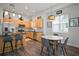 Modern kitchen with stainless steel appliances, wooden cabinets, a center island with seating, and a dining area at 11227 Moultrie Pl, Tampa, FL 33625