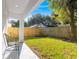 Green backyard with a modern patio and chairs, enclosed by a wood fence for privacy at 116 W Stanley St, Tampa, FL 33604