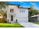 Modern two-story home featuring a balcony, manicured lawn, and a two-car garage at 116 W Stanley St, Tampa, FL 33604