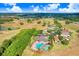 A birds-eye view highlights the beautiful community pool and tennis courts amidst a lush green landscape at 1177 Emerald Hill Way, Valrico, FL 33594