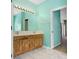 Bathroom with wood vanity and double sinks, large mirror, and entrance to another room at 1177 Emerald Hill Way, Valrico, FL 33594
