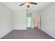 Bedroom with a ceiling fan and neutral carpet; two open doorways lead to other rooms at 1177 Emerald Hill Way, Valrico, FL 33594