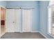 Bedroom featuring a closet with mirrored doors, a window, and light blue walls at 1177 Emerald Hill Way, Valrico, FL 33594