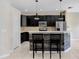 Modern kitchen with stainless steel appliances, breakfast bar, and sleek black cabinetry at 1177 Emerald Hill Way, Valrico, FL 33594
